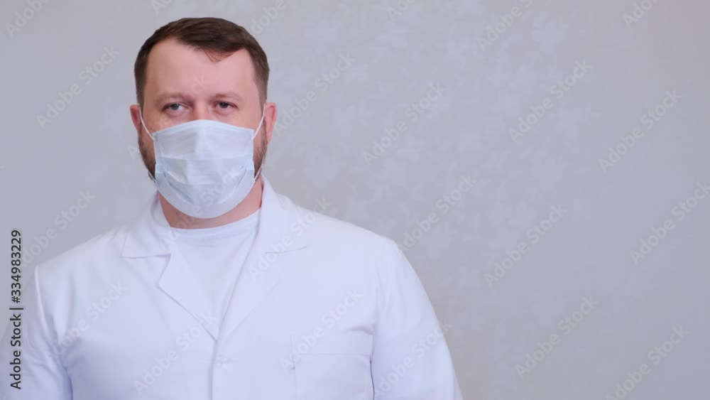 Male in a protective mask and a white shirt looks at the camera, close-up. Hygiene concept. prevent the spread of germs and bacteria and avoid infection with the crown virus. copy space Male in a protective mask and a white shirt looks at the camera, close-up. Hygiene concept. prevent the spread of germs and bacteria and avoid infection with the crown virus. copy space