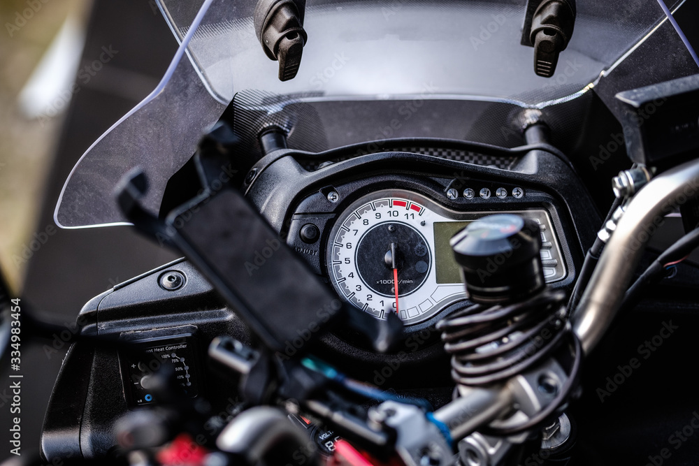 Motorcycle details close up. Motorbike speedometer, warning lights, mobile device holder. Close up, selective focus