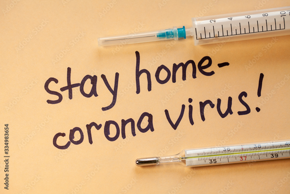 Flat lay. Phrase on white paper with black marker Stay Home. Doctor makes a warning. Stay at home. Coronovirus COVID-19 concept Flat lay. Phrase on white paper with black marker Stay Home. Doctor makes a warning. Stay at home. Coronovirus COVID-19 concept