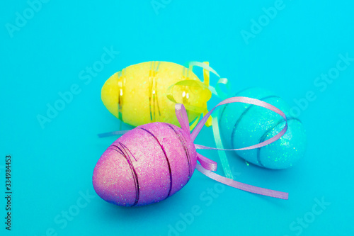Three Easter toy eggs on a blue background.