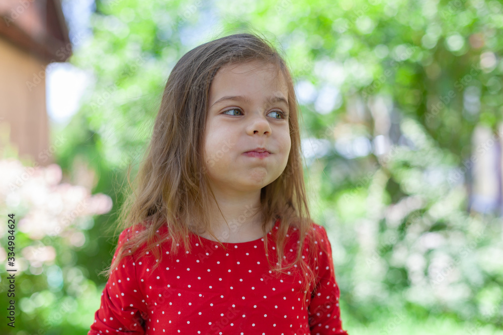 Young girl is holding raspberries on her fingers, outdoor shoot Young girl is holding raspberries on her fingers, outdoor shoot