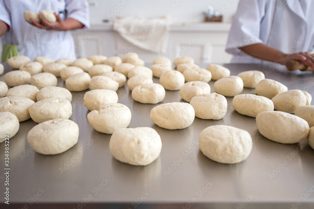 Brown Women Using a White Food Uniform is Making Bread with Flour Dough Brown Women Using a White Food Uniform is Making Bread with Flour Dough
