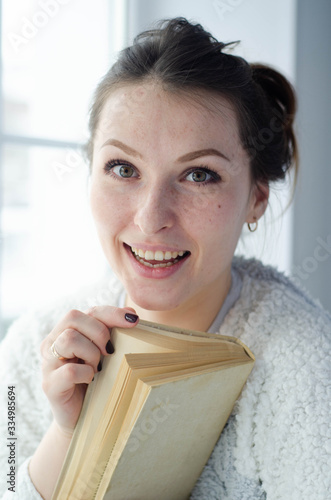 portrait of a young beautiful smiling girl with a book
