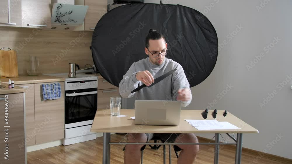 Man sells knives online on a laptop. Quarantine, working home, stay at home, coronavirus or Covid-19 Man sells knives online on a laptop. Quarantine, working home, stay at home, coronavirus or Covid-19