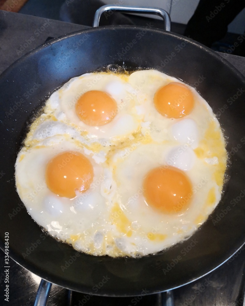 four fried eggs in cast iron pan, directly above four fried eggs in cast iron pan, directly above