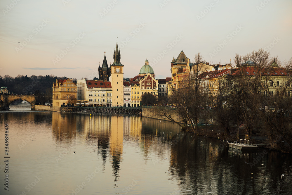 Famous Charles Bridge with 
chapel over the Vltava river in Prague, Czech Republic. View from the side Charles bridge on river Vltava in Prague. Reflection of building in river.