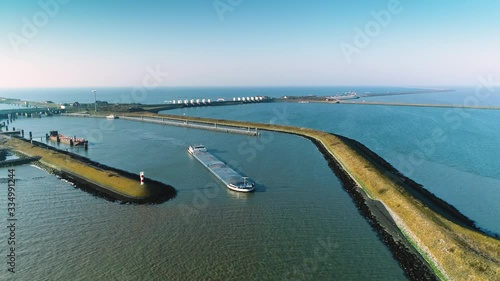 Enclosure Dam (Afsluitdijk): Large Cargo Ship with the Enclosure Dam Behind It, Zooming Out Overview - Friesland, Netherlands / Holland – 4K Drone Footage photo