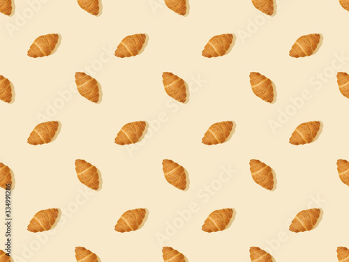 top view of fresh croissants on beige, seamless background pattern