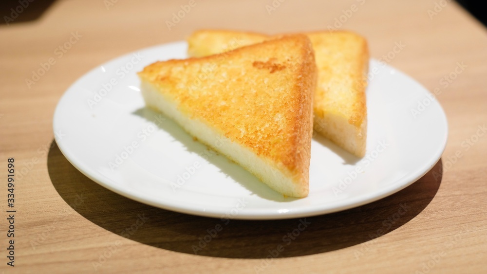 Selective focus of yellow or brown Grilled toast bread slices on white dish for breakfast Selective focus of yellow or brown Grilled toast bread slices on white dish for breakfast