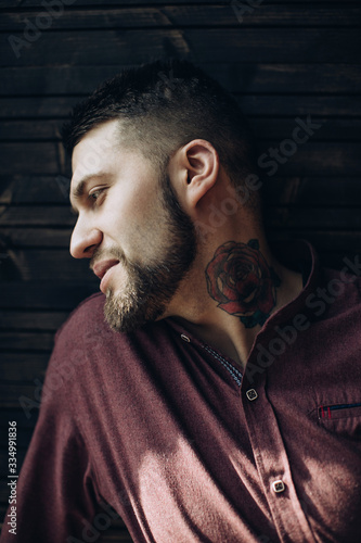  Portrait of a brutal bearded man with a tattoo on his neck