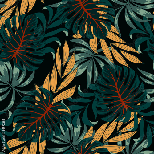 Original seamless tropical pattern with bright plants and leaves on a black background. Seamless pattern with colorful leaves and plants. Trendy summer Hawaii print.