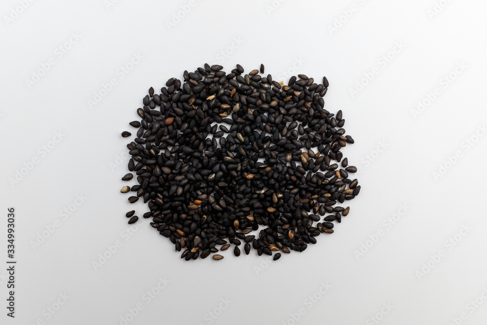 Small black sesame seeds on white background Small black sesame seeds on white background