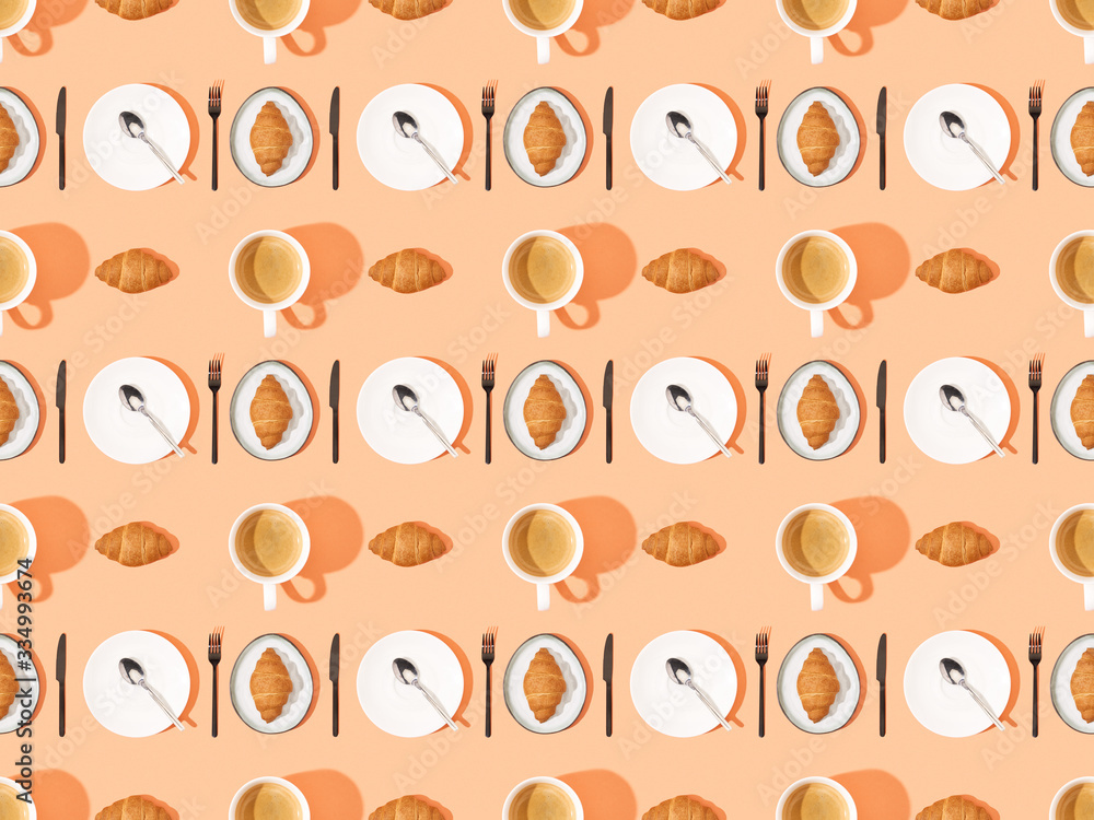 top view of cutlery, fresh croissants on plates and coffee on orange, seamless background pattern top view of cutlery, fresh croissants on plates and coffee on orange, seamless background pattern