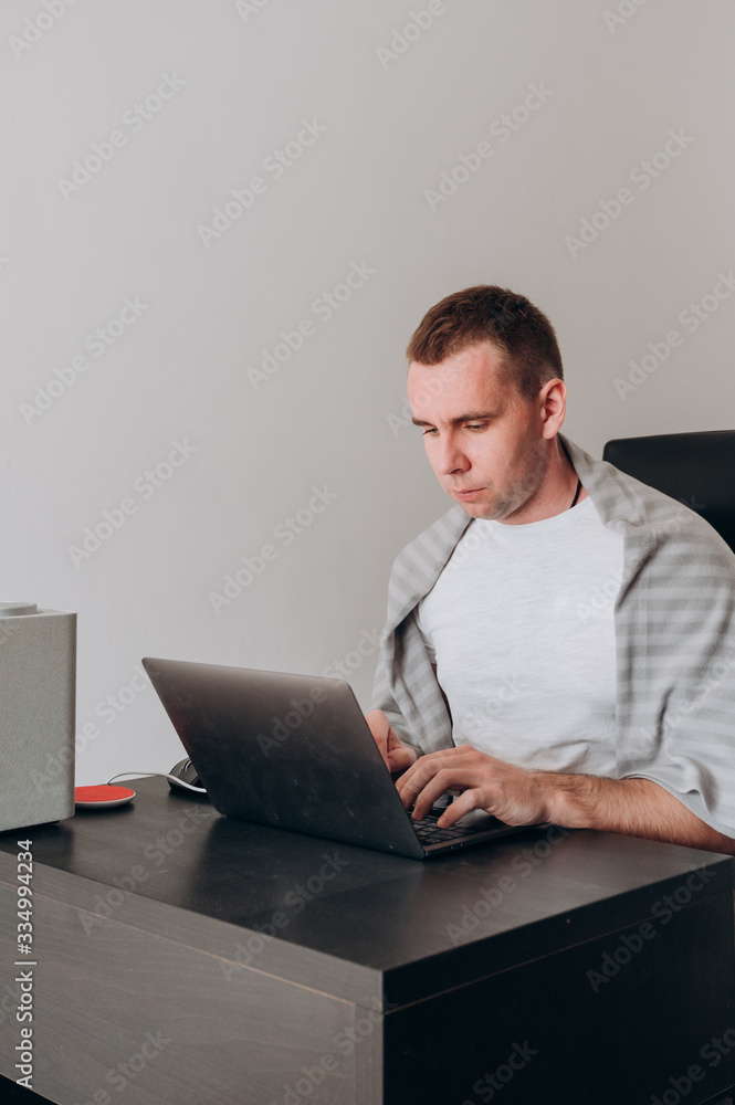 a young man works at home at a computer in quarantine a young man works at home at a computer in quarantine