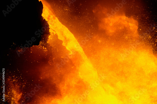 The release of pig iron from a blast furnace in a foundry through a channel into a cast iron truck. Cast iron bay in a foundry in cast iron trucks