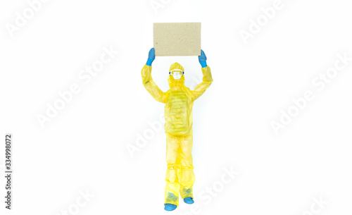 Toy man in hazmat suit holds a cardboard. Viral epidemic  biological  chemical  radioactive danger  mockup  copy space