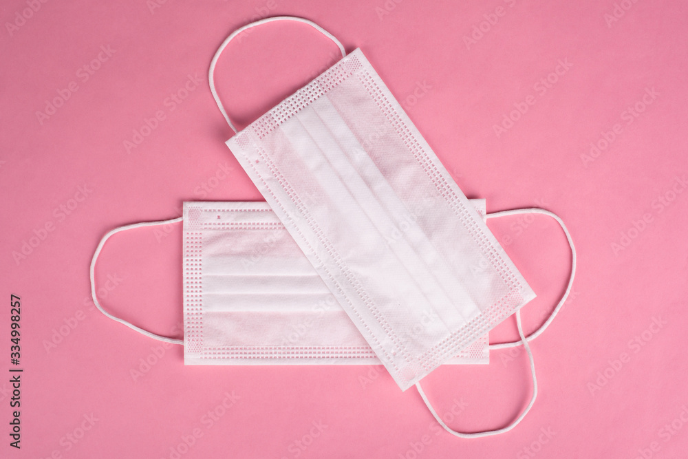 white protective medical masks on a pink background. Covid-19 pandemic 2020 white protective medical masks on a pink background. Covid-19 pandemic 2020