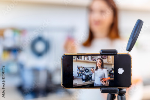 Tutorial di cucina in cui una ragazza in cucina viene ripresa da un cellulare e parla di una ricetta ai suoi followers