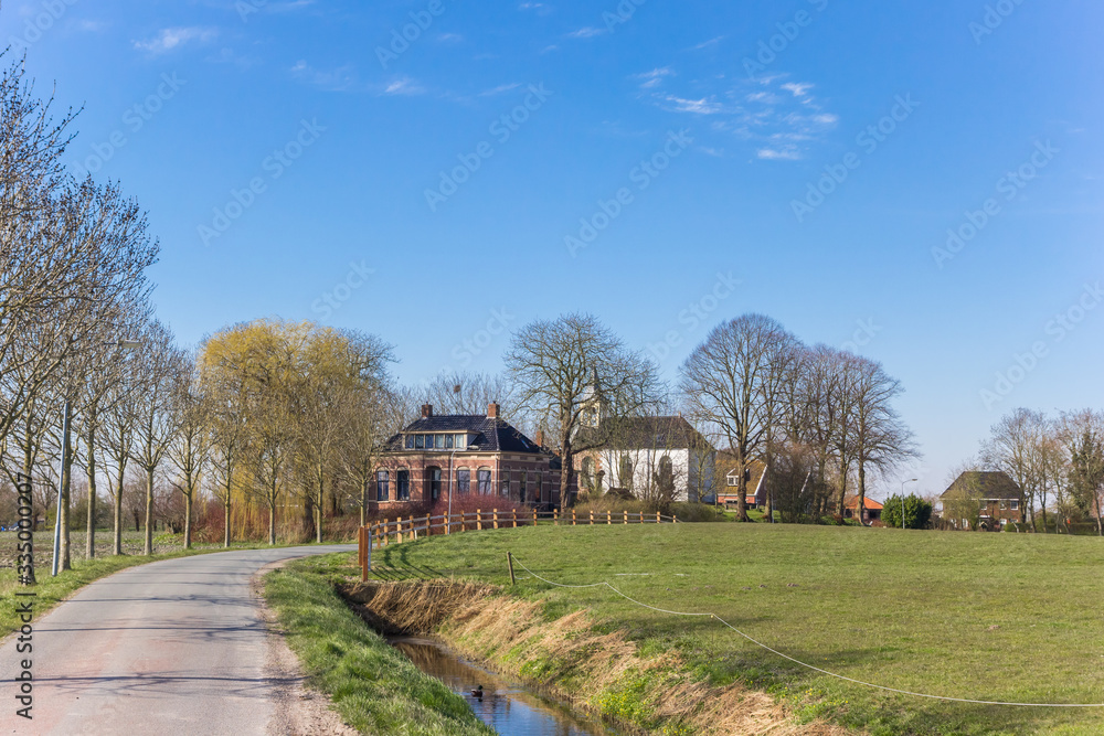 Road leading to the small village Jukwerd in Groningen, Netherlands Road leading to the small village Jukwerd in Groningen, Netherlands