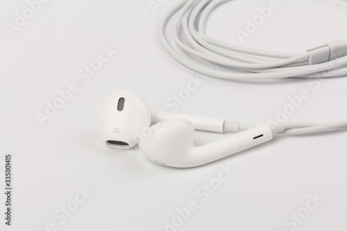 White headphones for listening to music and sound on portable devices: music player, smartphone, laptop and jack for connection on a white background.