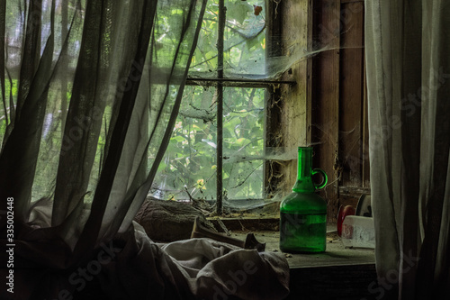 vorhang bei einem fenster mit einer gruenen flasche