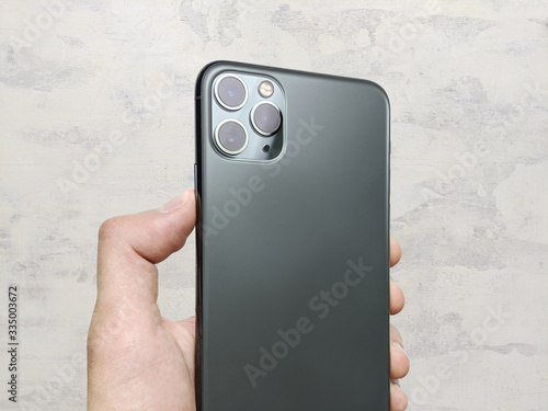 Wallpaper Mural Man hand holding the newest smartphone Torontodigital.ca