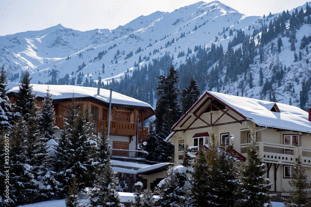 Winter holiday house in mountains. Mountain vacation houses at ski resort. Winter wonderland.