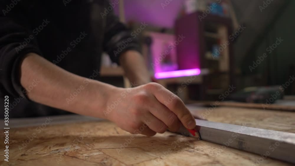 Hands Of Man Using A Ruler To Make Measurements On A Piece Of Wood. Holding a pencil. Slowmotion Hands Of Man Using A Ruler To Make Measurements On A Piece Of Wood. Holding a pencil. Slowmotion