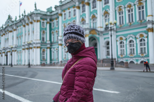Young woman in mask walk in the city. Empty dvortsovaya square in the centre on self isolation photo