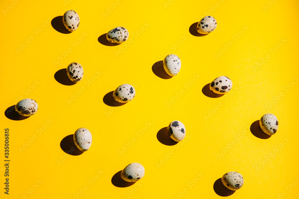 Quail eggs pattern on a yellow background top view