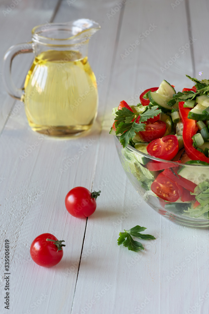 Salad on a white wooden background from tomatoes, cucumber, lettuce and red pepper. Healthy eating concept. Salad on a white wooden background from tomatoes, cucumber, lettuce and red pepper. Healthy eating concept.