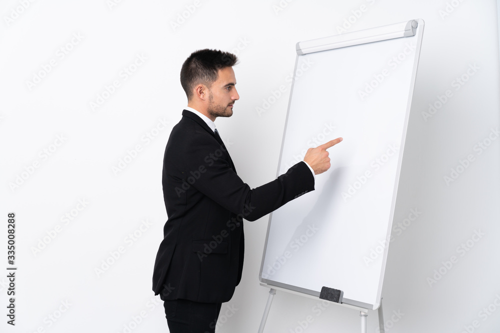 Young man giving a presentation on white board and writing in it Young man giving a presentation on white board and writing in it