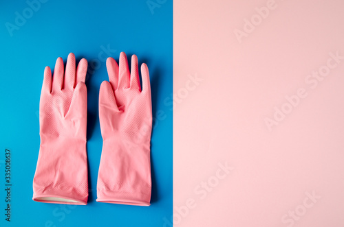 Pink cleaning gloves on coloful background © Ольга Кан