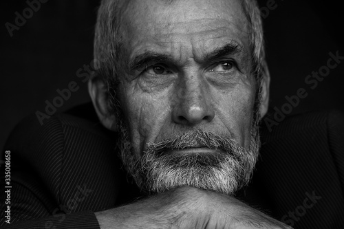 Fabulous at any age concept. Close up portrait of handsome mature man with beard and moustache. Monochrome indoor shot. Closed on quarantine. Text space.
