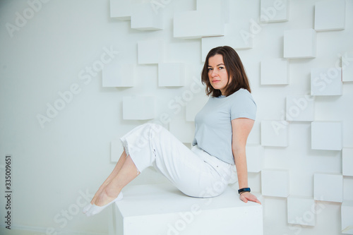 Young happy woman in casual clothes posing at studio.