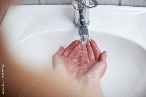 washing hands at bathroom sink man hand hygiene for corona virus pandemic precaution by washing hands frequently for 30 seconds photo