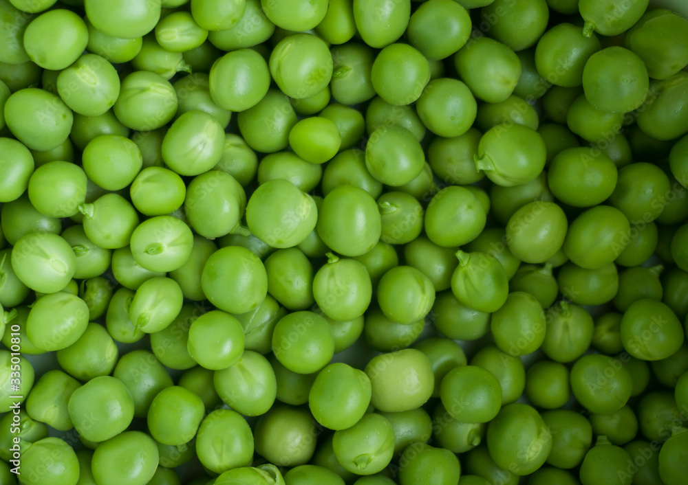 Green pea closeup macro. Horizontal photo of peeled peas on the market bench / counter / stand. Vegetable of summer season. Green pea closeup macro. Horizontal photo of peeled peas on the market bench / counter / stand. Vegetable of summer season.