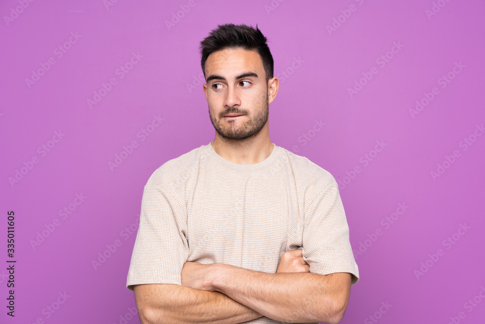 Young handsome man over isolated purple background with confuse face expression Young handsome man over isolated purple background with confuse face expression
