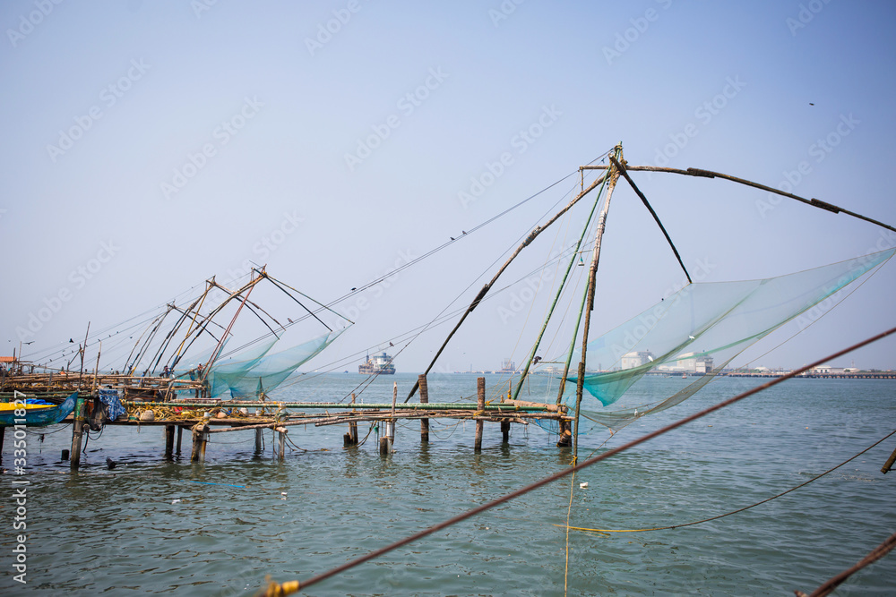 Chinese fishing nets are a tourist attraction in the Indian city of Kochi in Kerala. Large nets on the pier by the sea, fishermen and tourists