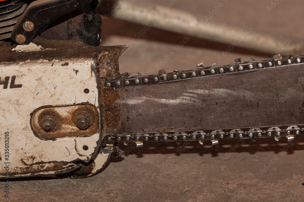 Old chainsaw in workshop. Defective chainsaw on service