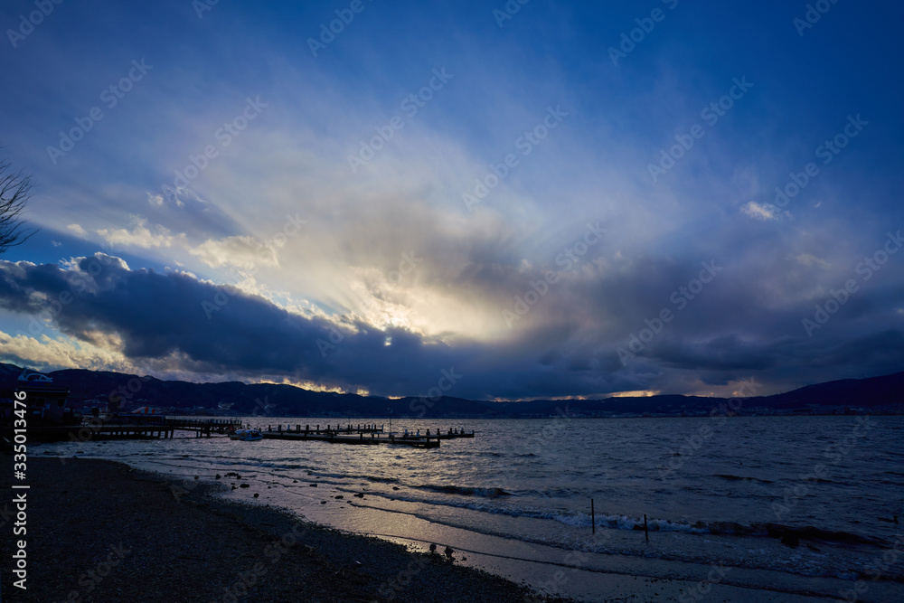 Lake in a windy day, landscape where sunlight can be seen through a gap in a cloudy sky.