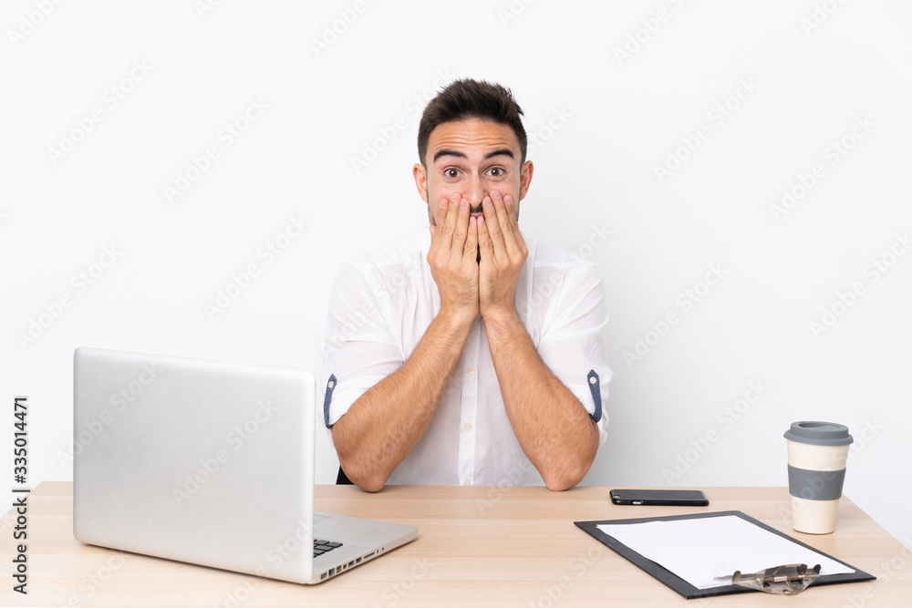 Young business man with a mobile phone in a workplace with surprise facial expression Young business man with a mobile phone in a workplace with surprise facial expression