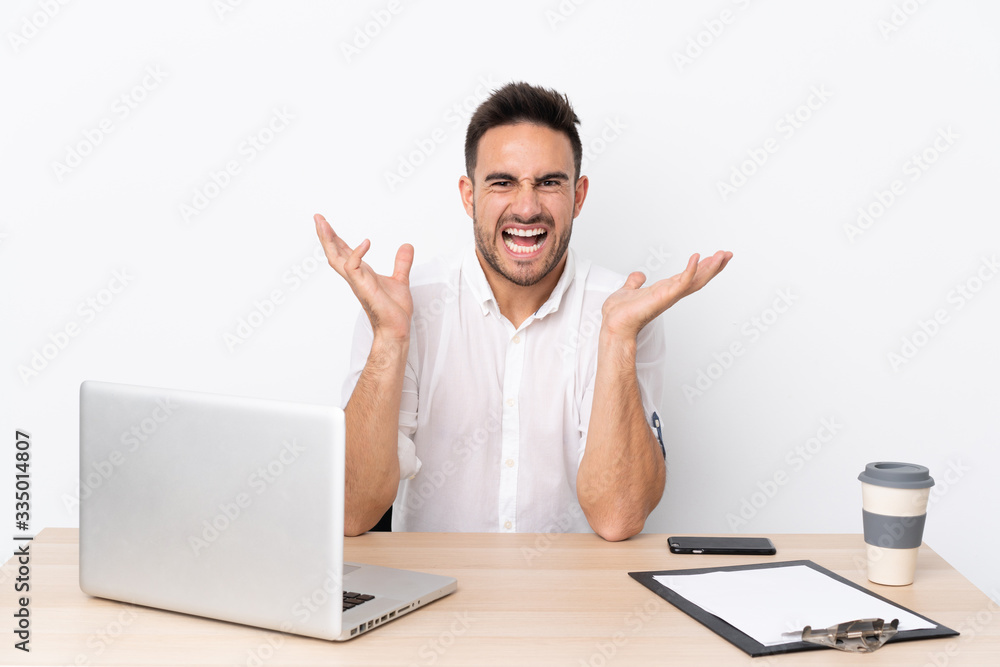 Young business man with a mobile phone in a workplace unhappy and frustrated with something Young business man with a mobile phone in a workplace unhappy and frustrated with something