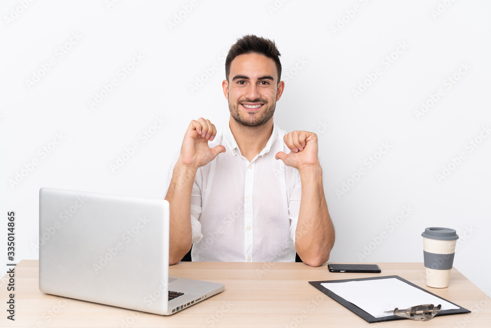 Young business man with a mobile phone in a workplace proud and self-satisfied Young business man with a mobile phone in a workplace proud and self-satisfied