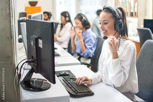 Attractive woman working with customer on hotline support in call center photo
