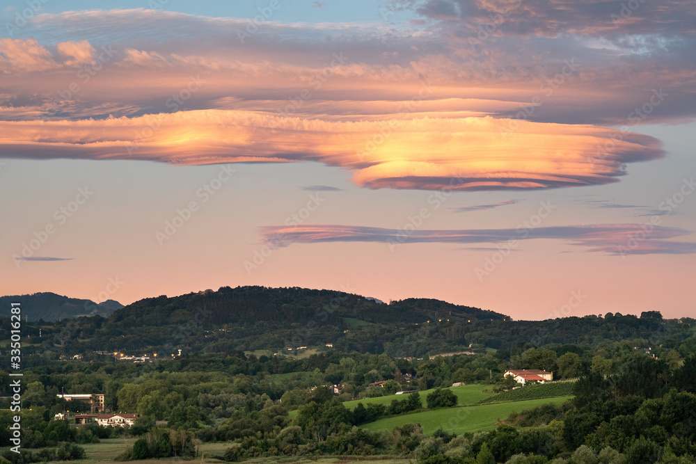 Amazing colorful lenticular clouds over village in countryside. Irun, Basque Country, Spain. Camino de Santiago