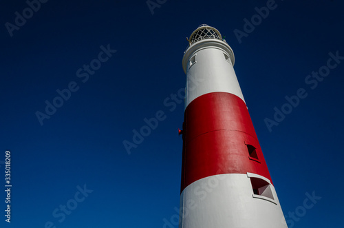 Obraz na płótnie Looking up at Portland Bill lighthouse against the contrast of a deep blue summer sky, Isle of Portland, Dorset, UK w salonie