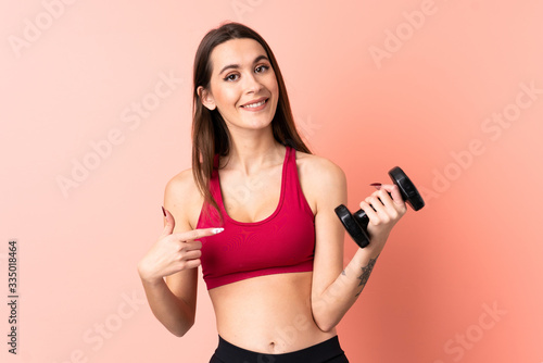 Young sport woman making weightlifting over isolated pink background with surprise facial expression © luismolinero