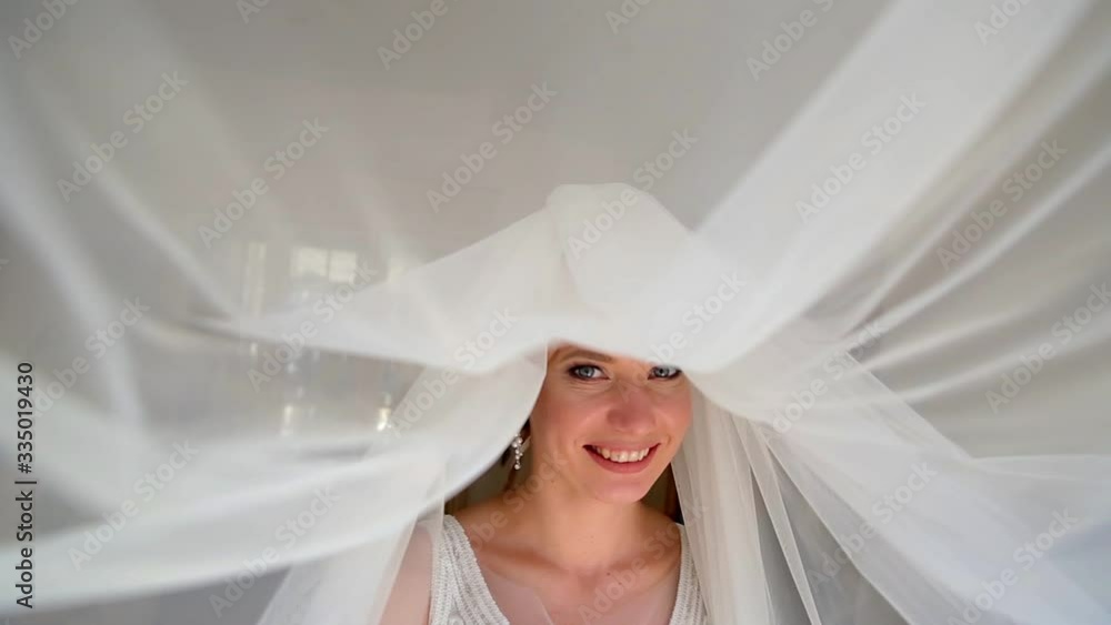Adorable young bride is getting ready in the morning at home. The bride getting ready for the wedding is dressed in a white dress Adorable young bride is getting ready in the morning at home. The bride getting ready for the wedding is dressed in a white dress