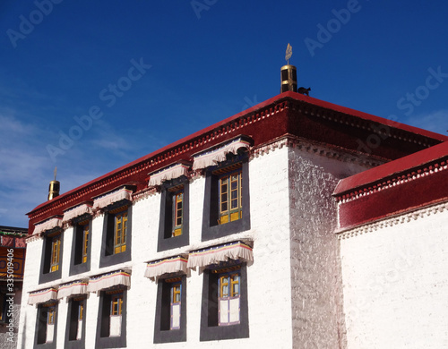Building with red roof and many windows in Tibet
